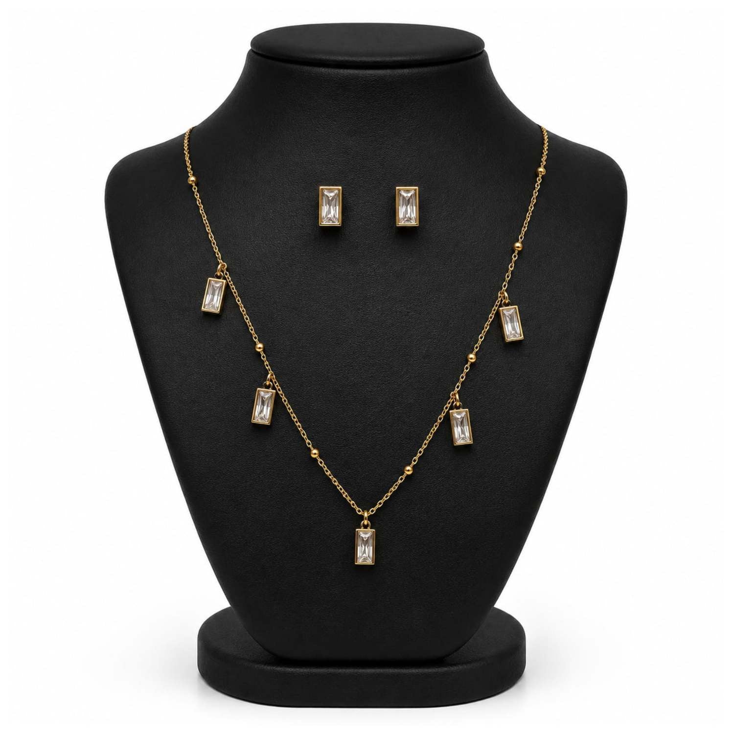 Gold-tone necklace and matching stud earrings displayed on a black jewelry bust against a white background.