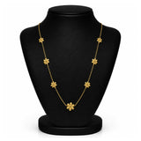 A gold floral necklace displayed on a black jewelry bust against a white background.