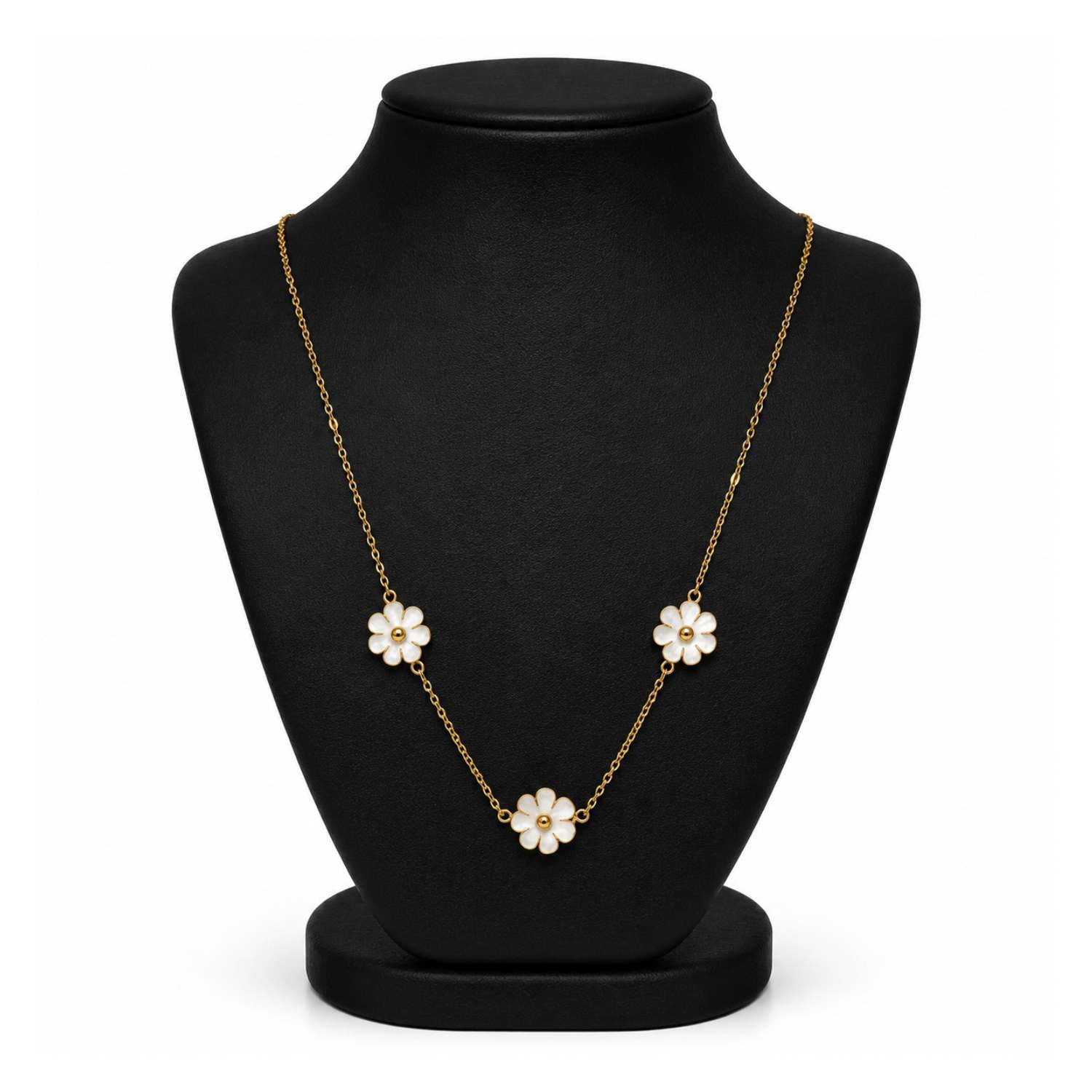 A gold chain necklace with three white flower charms, displayed on a black jewelry bust against a white background.