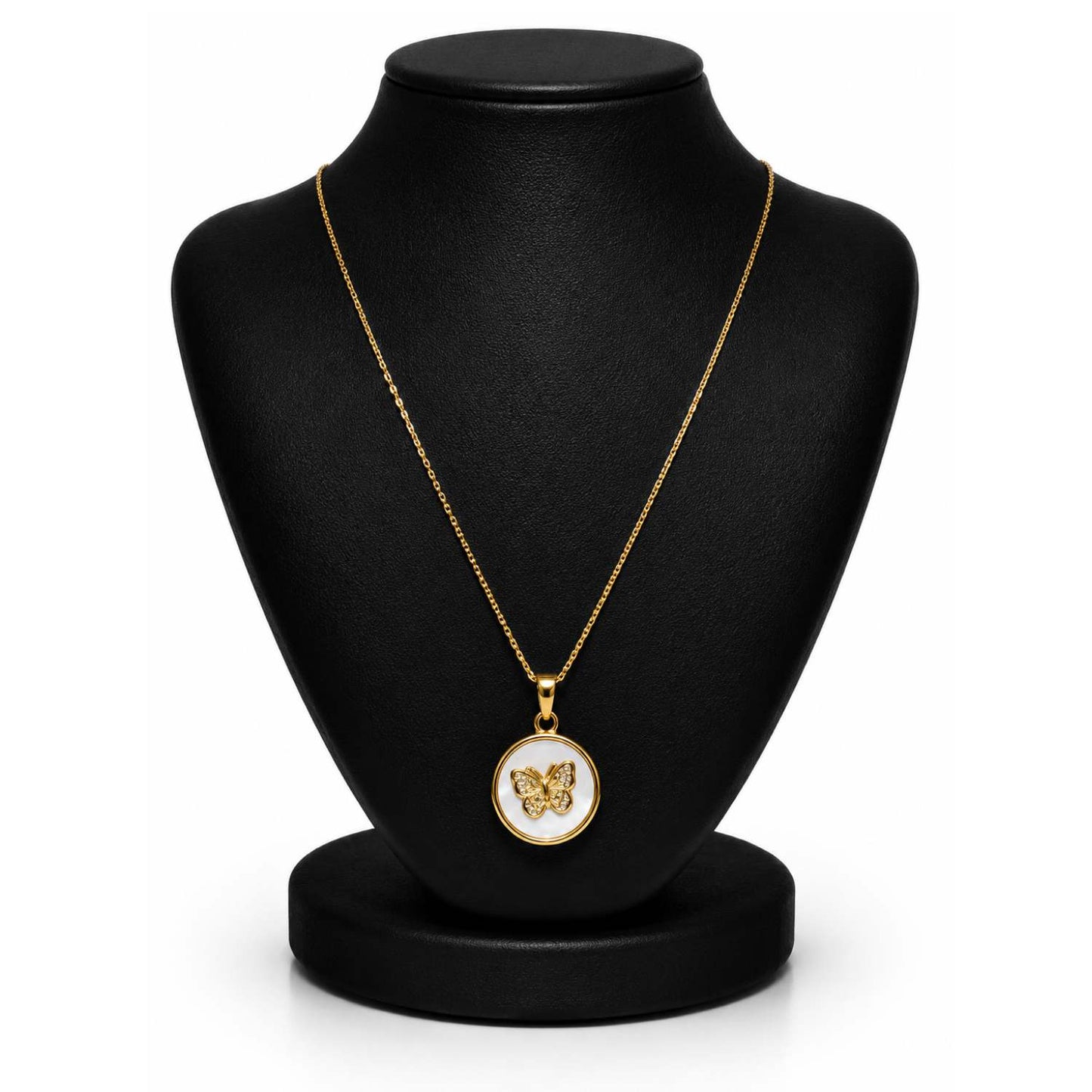A gold pendant necklace displayed on a black jewelry bust against a white background. The pendant features a butterfly motif set against a white circular background with a gold border.
