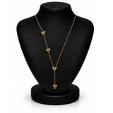 A gold lariat-style necklace with four dangling open heart charms, displayed on a black jewelry bust against a white background.