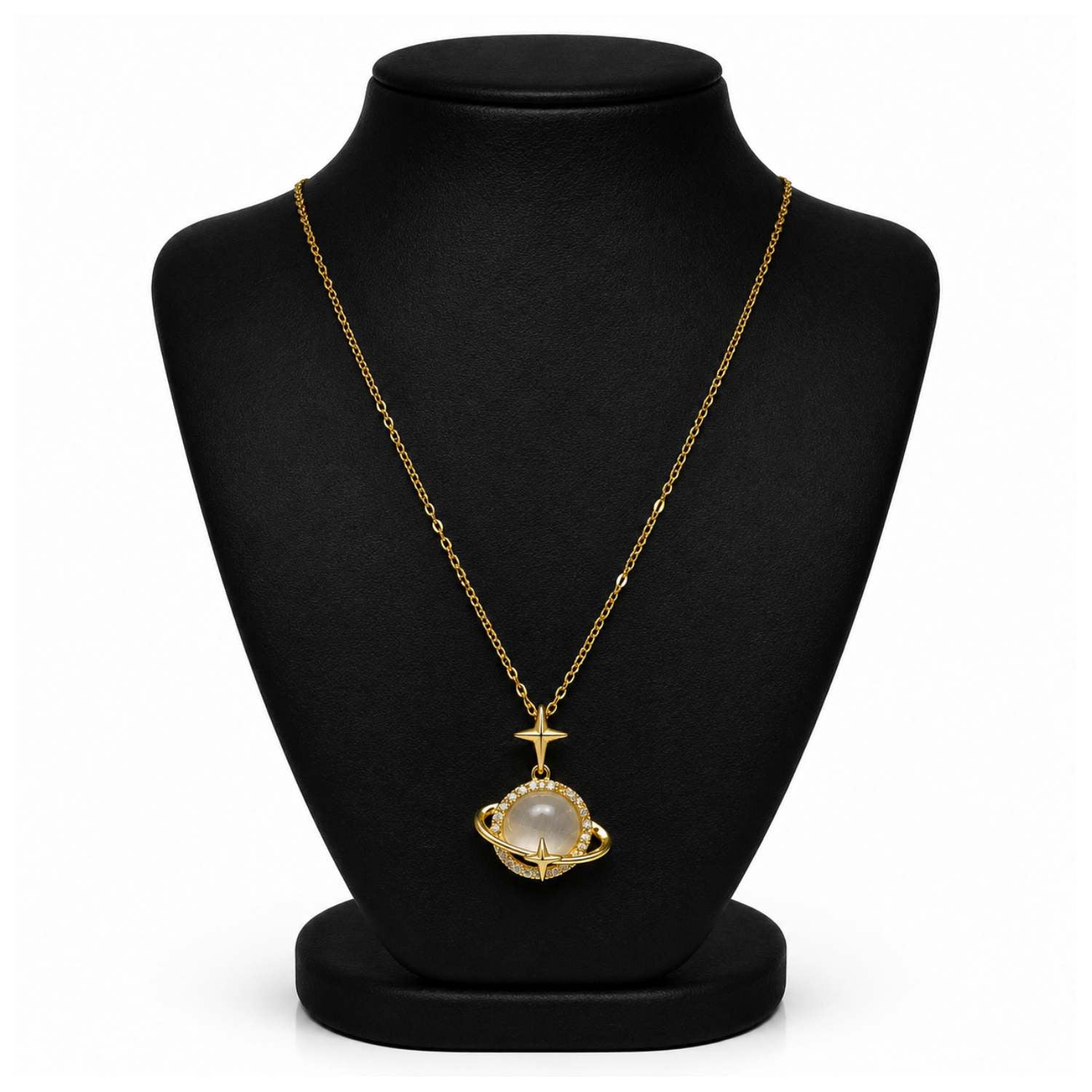 A gold chain necklace with a pendant featuring a white pearl-like stone and a small gold cross above it, displayed on a black jewelry bust against a white background.
