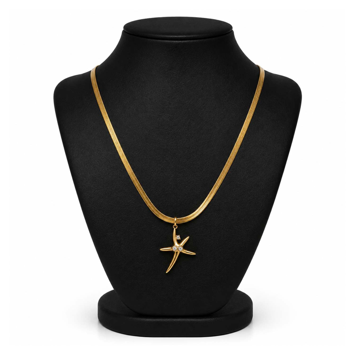 A gold chain necklace with a starfish pendant displayed on a black jewelry bust against a white background.