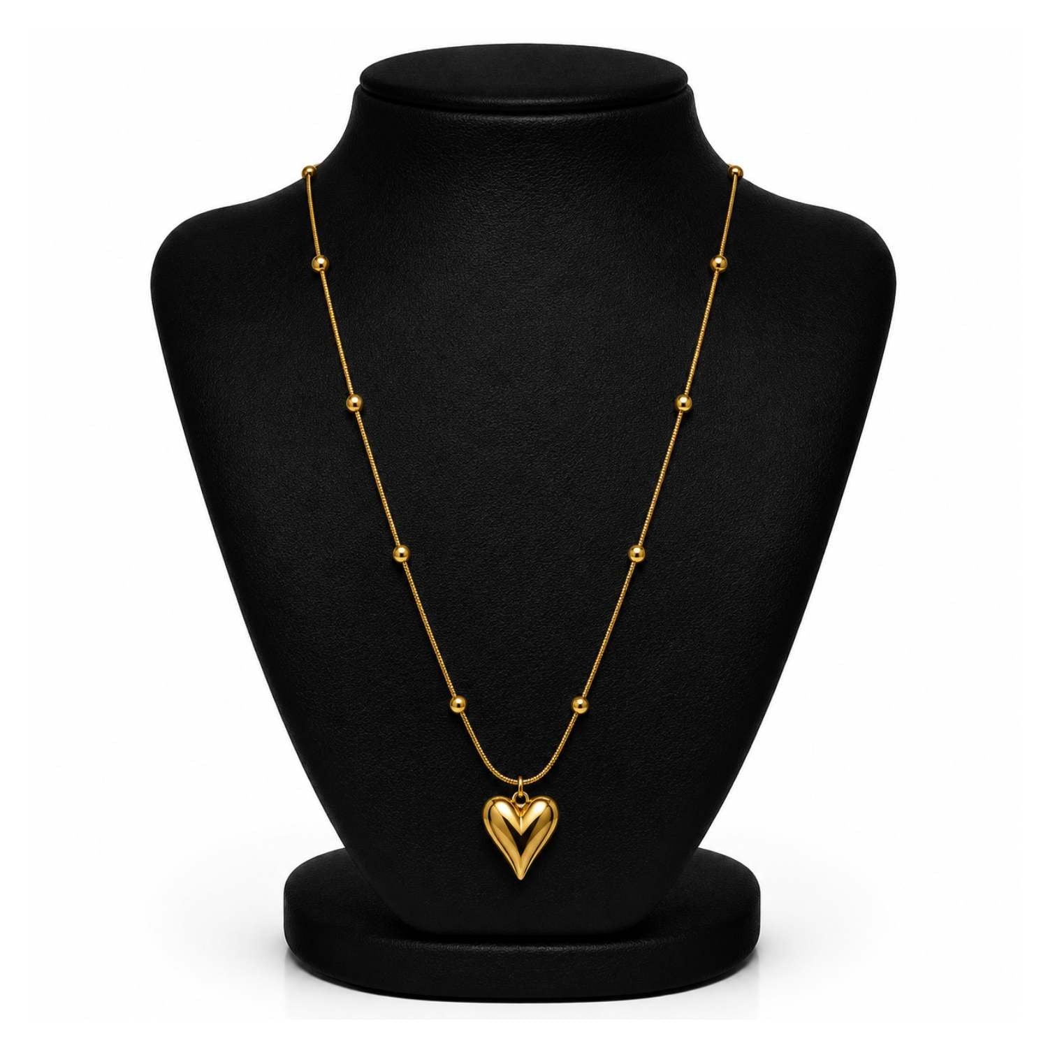 A gold heart pendant necklace displayed on a black jewelry bust against a white background.