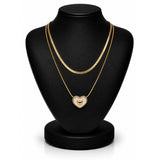 A double-strand gold chain necklace with a heart-shaped pendant displayed on a black jewelry bust against a white background.