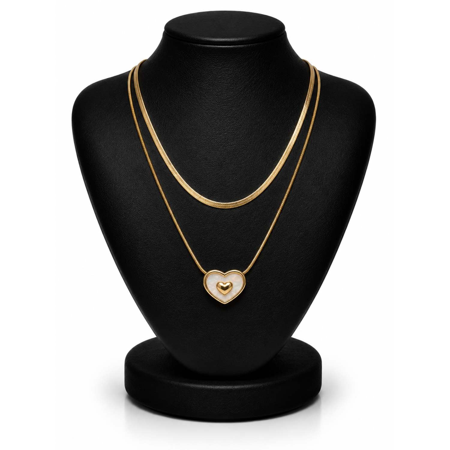 A double-strand gold chain necklace with a heart-shaped pendant displayed on a black jewelry bust against a white background.