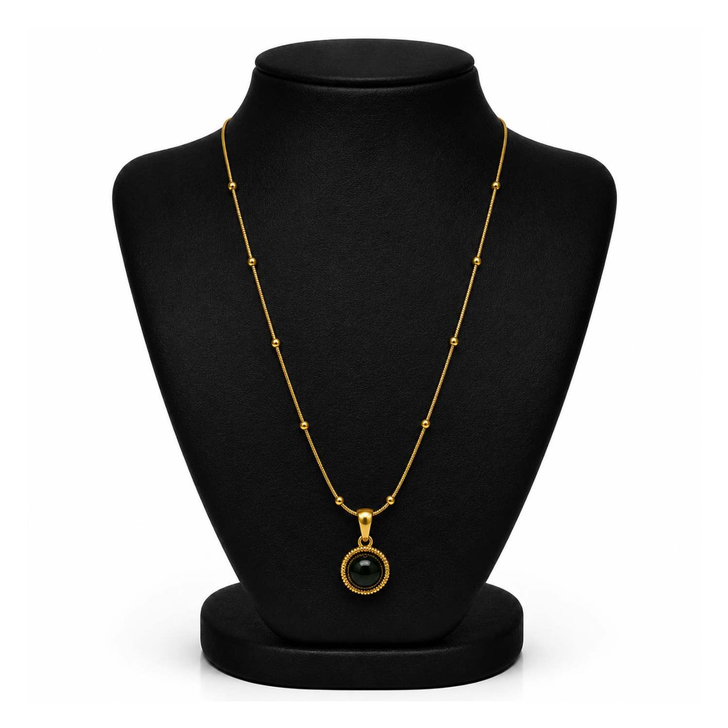 A gold chain necklace with a round bezel-set black gemstone pendant, displayed on a black jewelry bust against a white background.