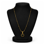 A gold chain necklace with a round bezel-set black gemstone pendant, displayed on a black jewelry bust against a white background.