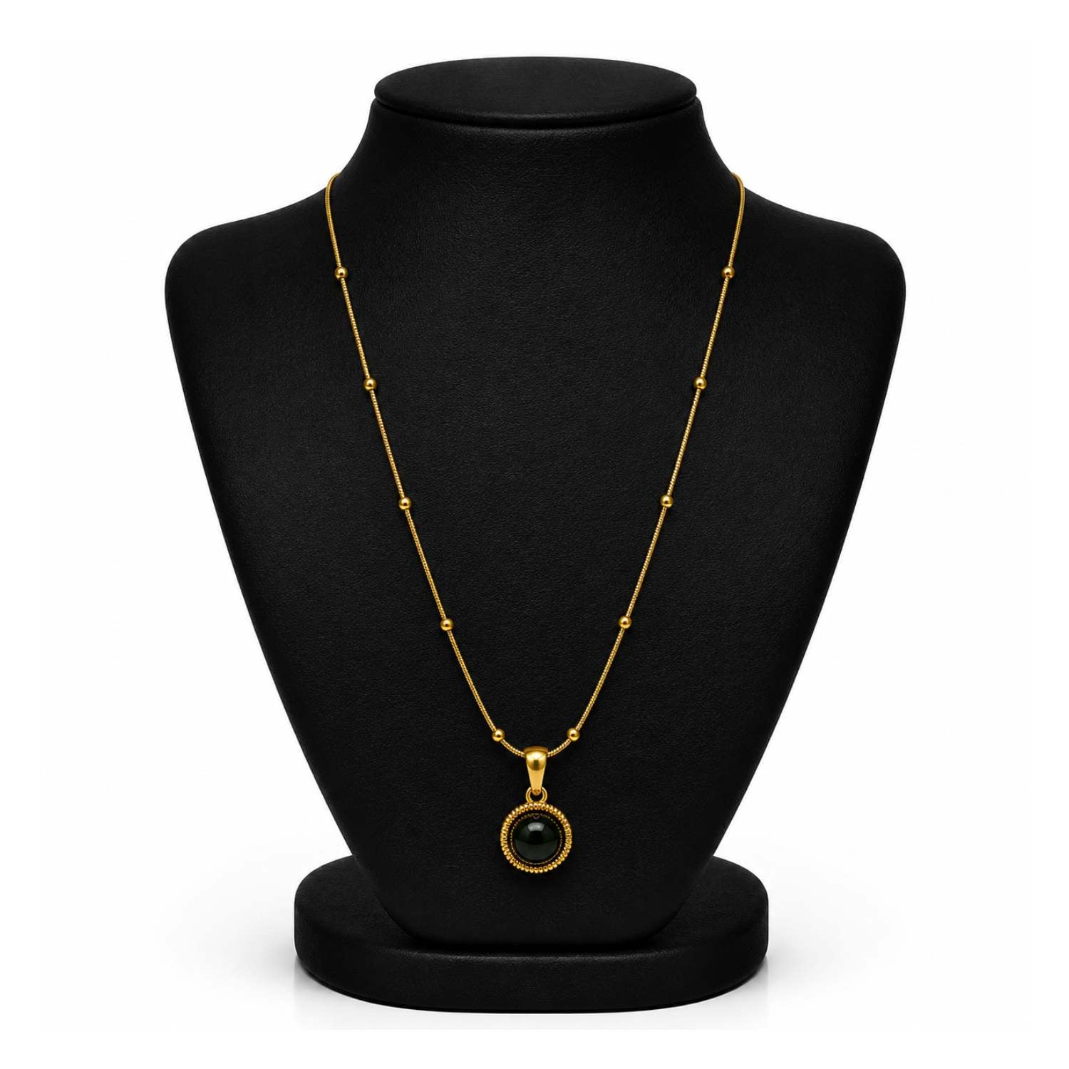 A gold chain necklace with a round bezel-set black gemstone pendant, displayed on a black jewelry bust against a white background.