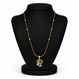 A gold necklace with a multi-colored pendant displayed on a black jewelry bust. The pendant features green, blue, and red stones set in gold.