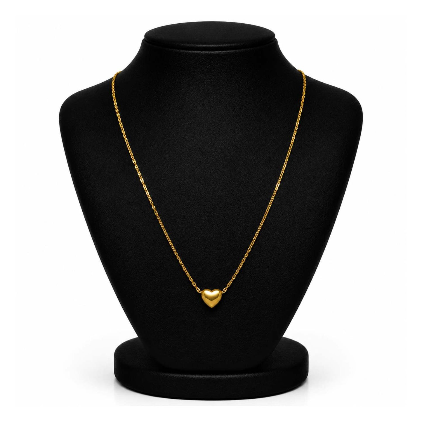 A delicate gold chain necklace with a small heart-shaped pendant, displayed on a black jewelry bust against a white background.