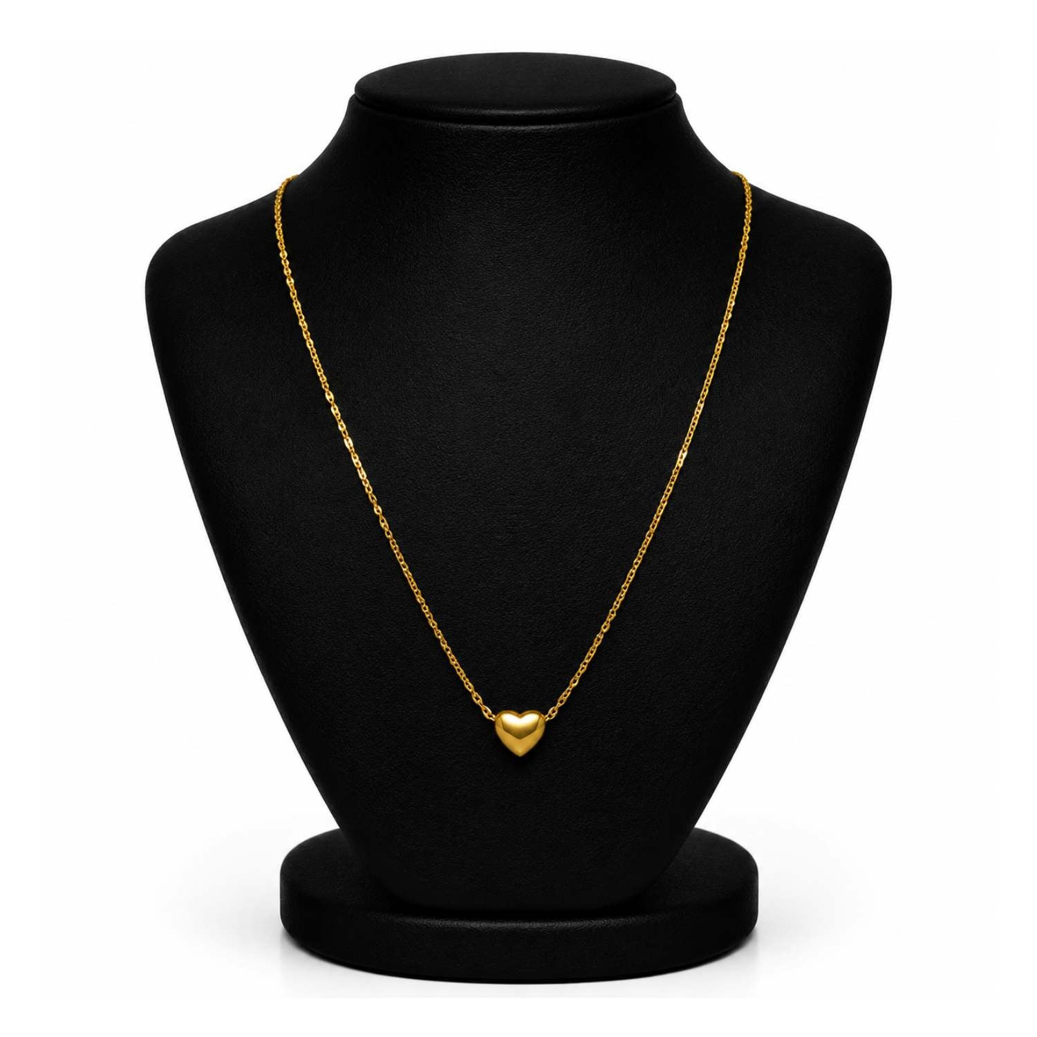A delicate gold chain necklace with a small heart-shaped pendant, displayed on a black jewelry bust against a white background.