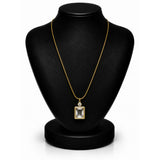 A gold chain necklace with a square bezel-set clear gemstone pendant, displayed on a black jewelry bust against a white background.
