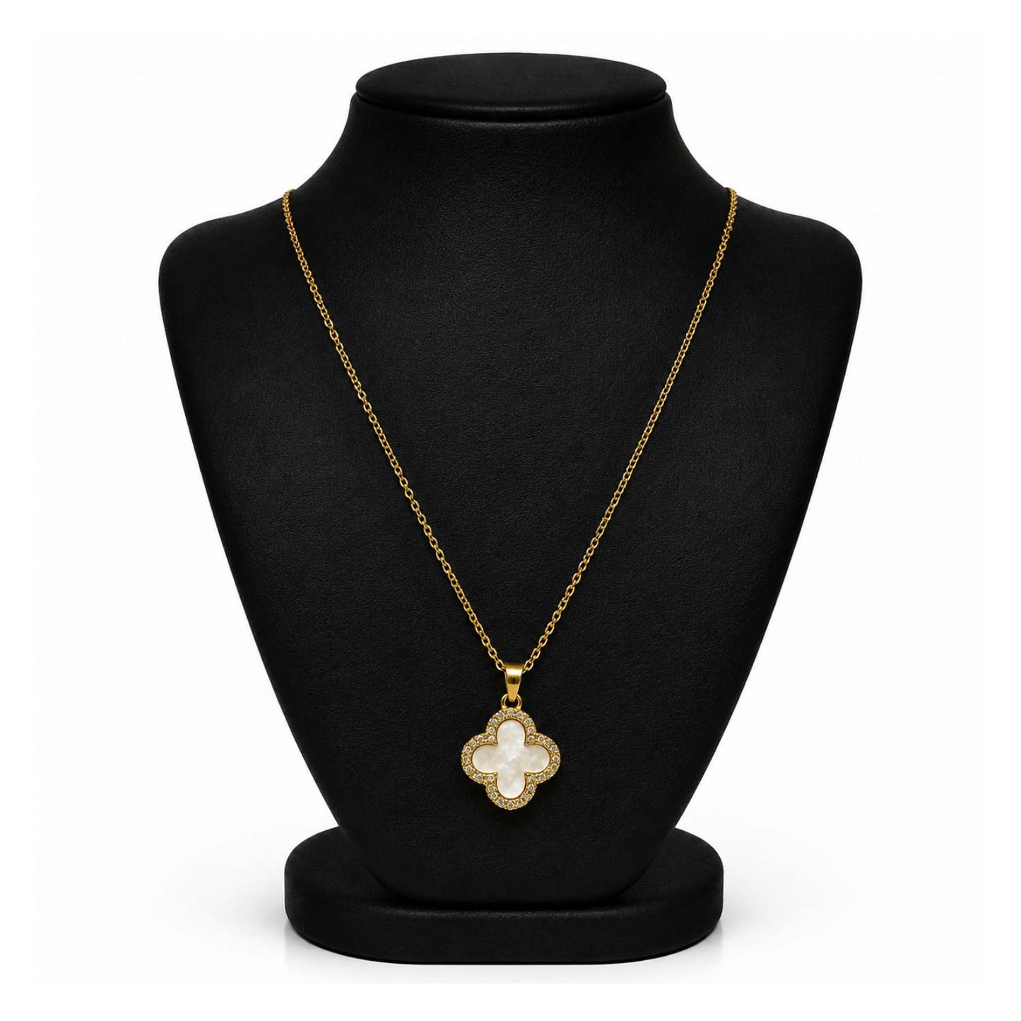 A gold-tone necklace with a mother-of-pearl clover pendant, displayed on a black velvet jewelry bust against a white background.