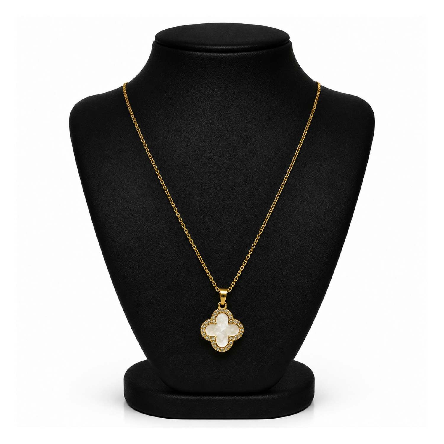 A gold-tone necklace with a mother-of-pearl clover pendant, displayed on a black velvet jewelry bust against a white background.